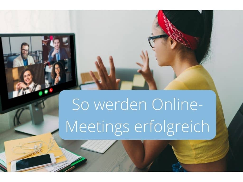 alt=„Frau in gelbem T Shirt sitzt am Schreibtisch und blickt auf vier Teilnehmende eines Online Meetings auf dem Bildschirm vor sich“
